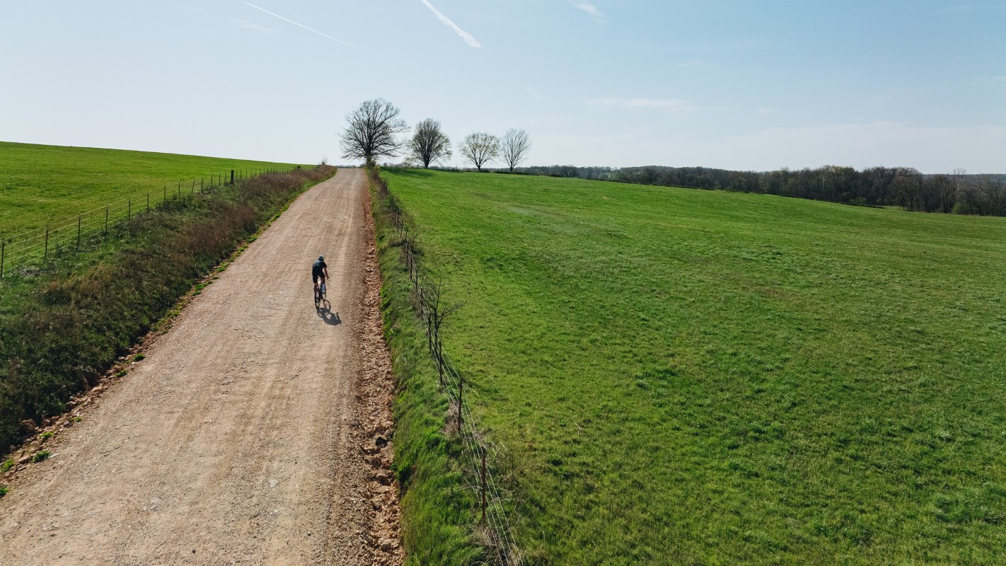 Dviratininkas važiuojantis gravel dviračiu žvyrekliu