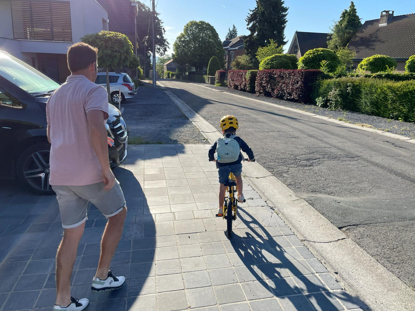 Tėvas mokina vaiką važiuoti dviračiu