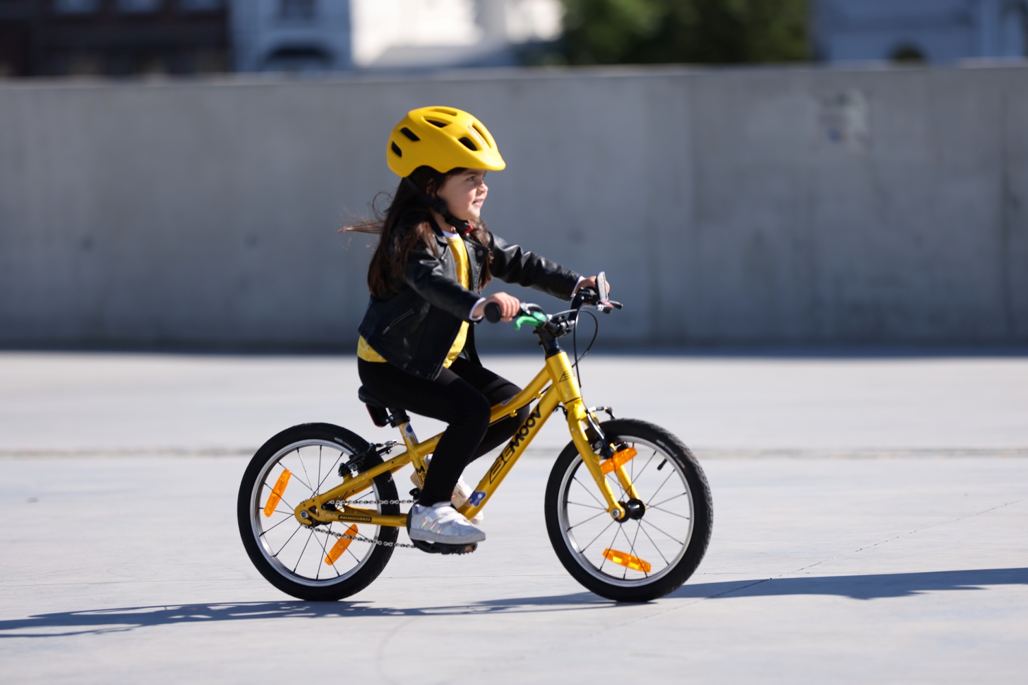 Mergaitė važiuojanti geltonu dviračiu