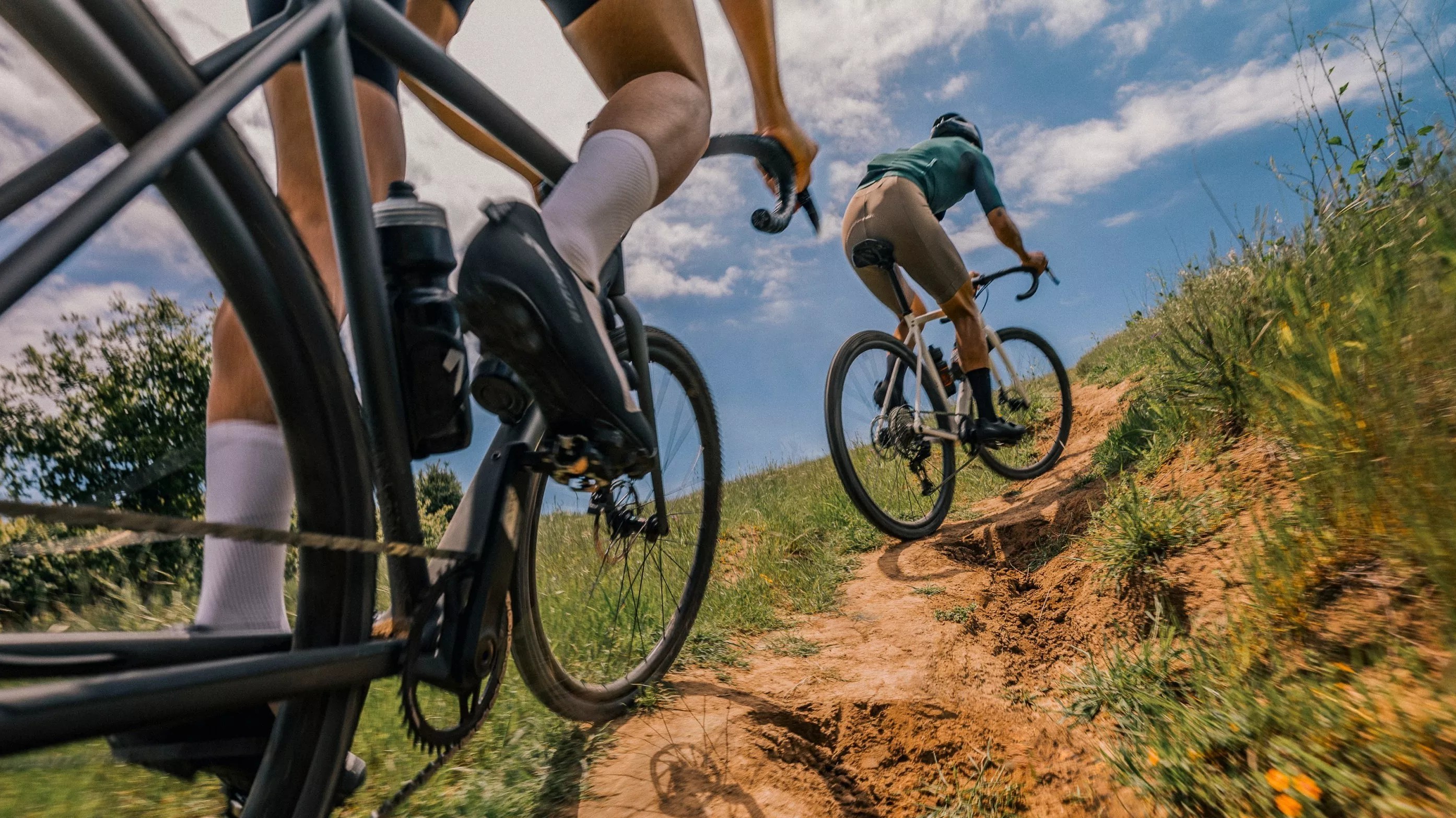 Du vyrai važiuojantys į kalną su gravel dviračiais