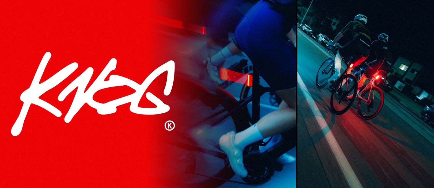 Du vyrai važiuojantys dviračiu tamsoje mieste su įjungtais žibintais