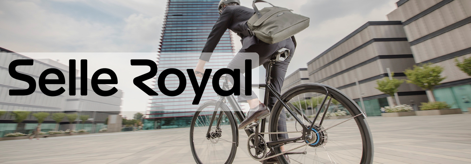 Vyras apsirengęs kostiumu važiuojantis dviračiu